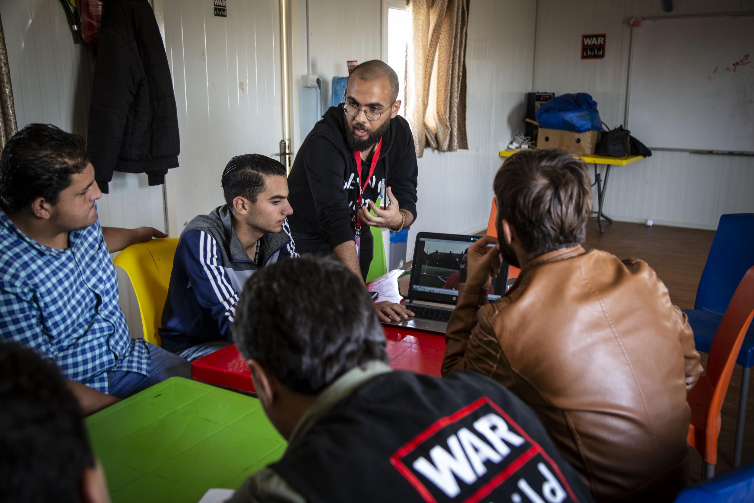 Syrian teenagers in Zaatari refugee camp watch a video from London school pupils as part of The Independent twinning programme