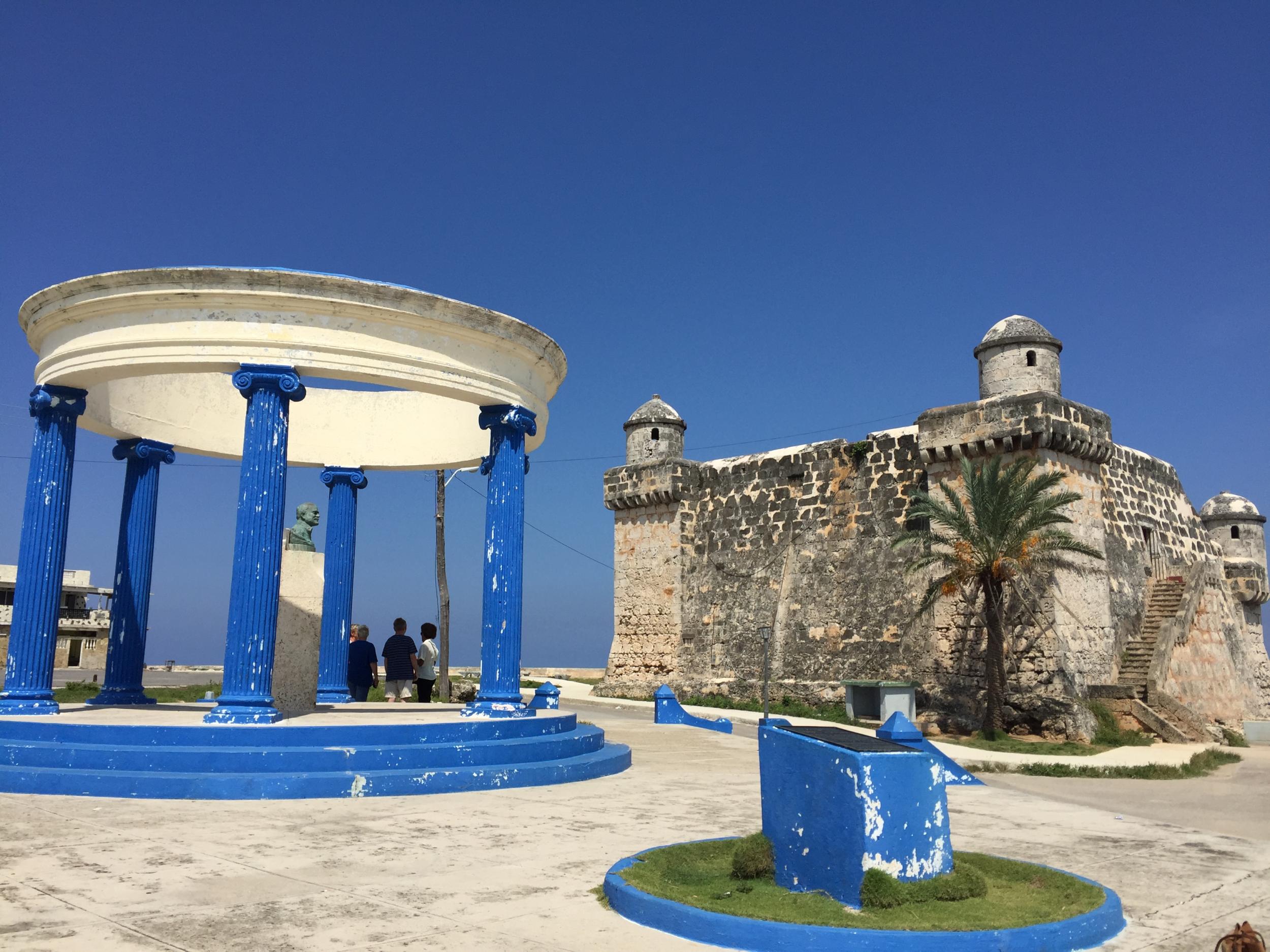 A Hemingway monument shelters under a blue pavilion