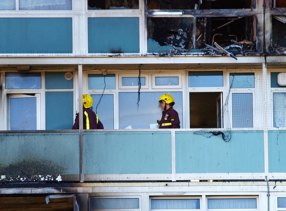Firemen on a balcony outside one of the burned out flats at Lakanal House in London, following a fire that killed six people on 4 July 2009