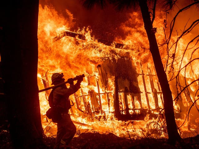 Flames from the Camp Fire consume a home in Magalia, California