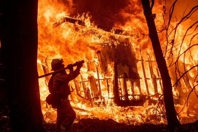 Flames from the Camp Fire consume a home in Magalia, California