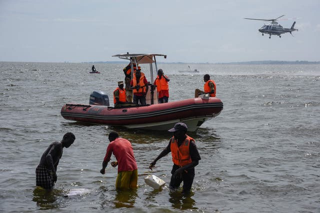 Rescuers search for victims the day after the cruise boat capsized on Lake Victoria