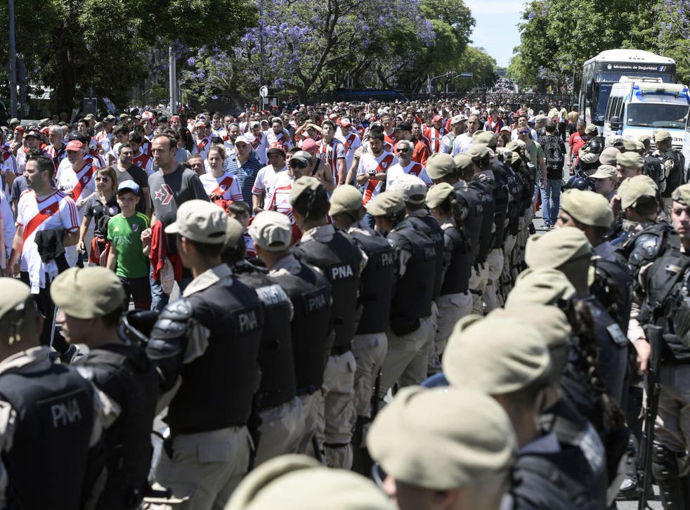 Security forces stand guard as River Plate's supporters leave Estadio Monumental