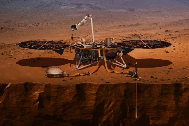 This illustration made available by NASA in 2018 shows the InSight lander drilling into the surface of Mars