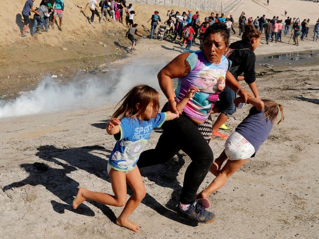 A migrant family from Honduras runs from tear gas fired by US border patrol at Mexico border