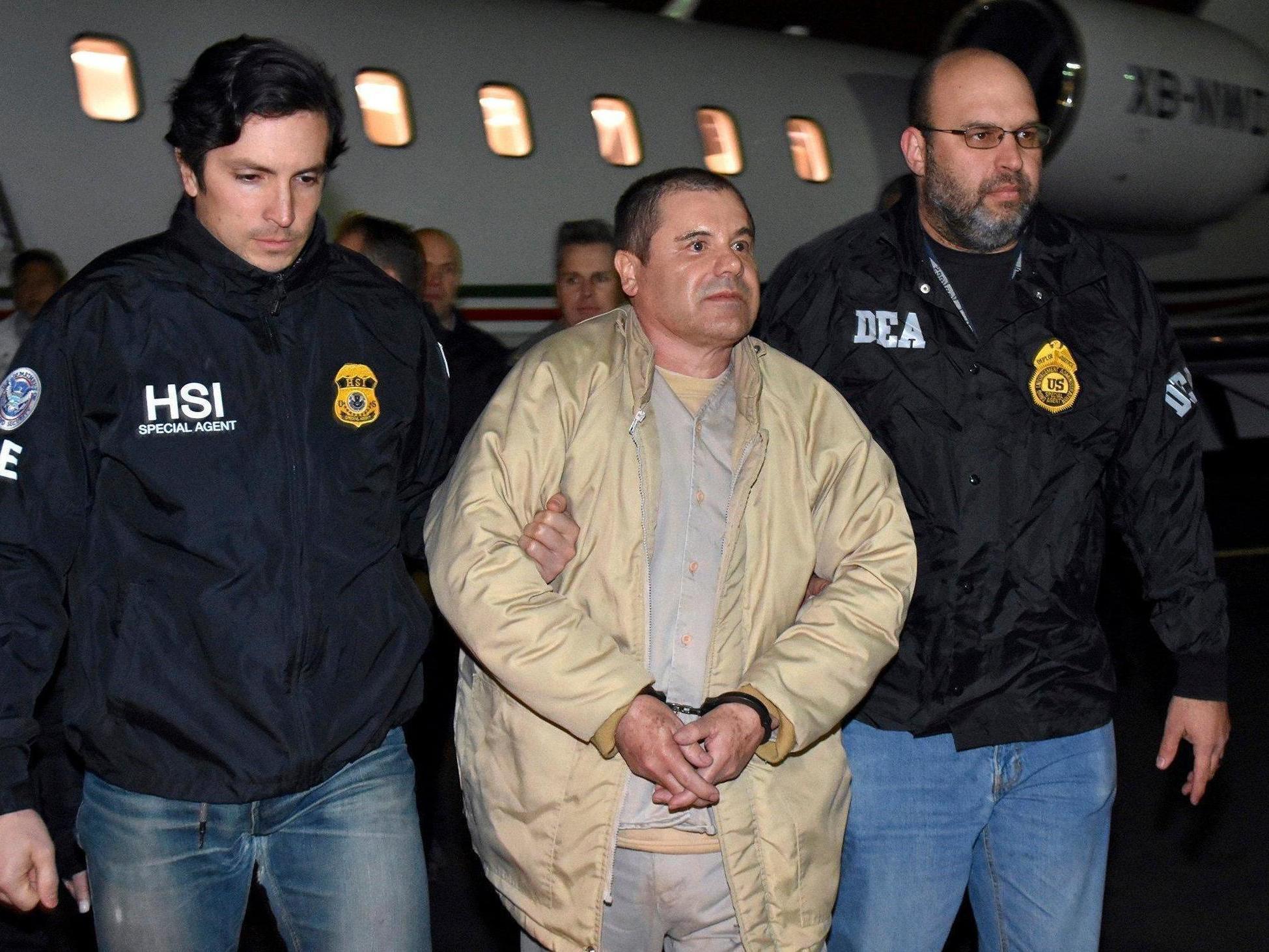 Authorities escort Mexican kingpin Joaquin 'El Chapo' Guzman, centre, from a plane to a waiting fleet of SUVs at Long Island MacArthur Airport, New York