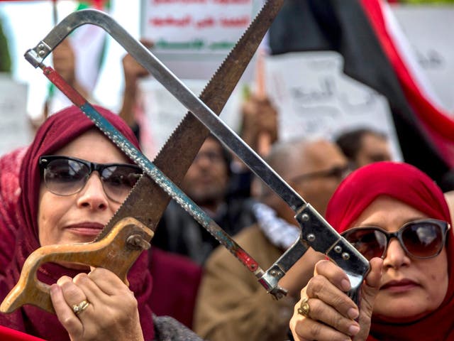 Tunisians demonstrate against the Saudi Crown Prince in Tunis on Tuesday, holding saws in reference to the murder of Jamal Khashoggi