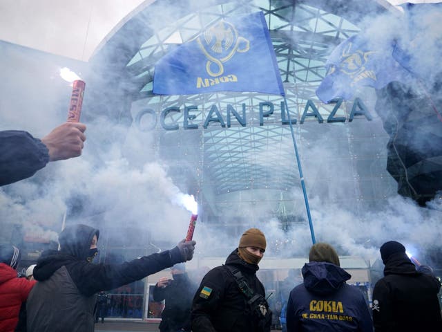 Ukrainian far-right group activists hold flares in Kiev on Tuesday, as they block work on a shopping mall belonging to Russian oligarch Boris Rotenberg, a figure close to President Vladimir Putin, as Ukraine's parliament has approved the introduction of martial law