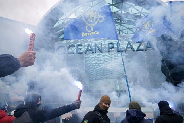 Ukrainian far-right group activists hold flares in Kiev on Tuesday, as they block work on a shopping mall belonging to Russian oligarch Boris Rotenberg, a figure close to President Vladimir Putin, as Ukraine's parliament has approved the introduction of martial law