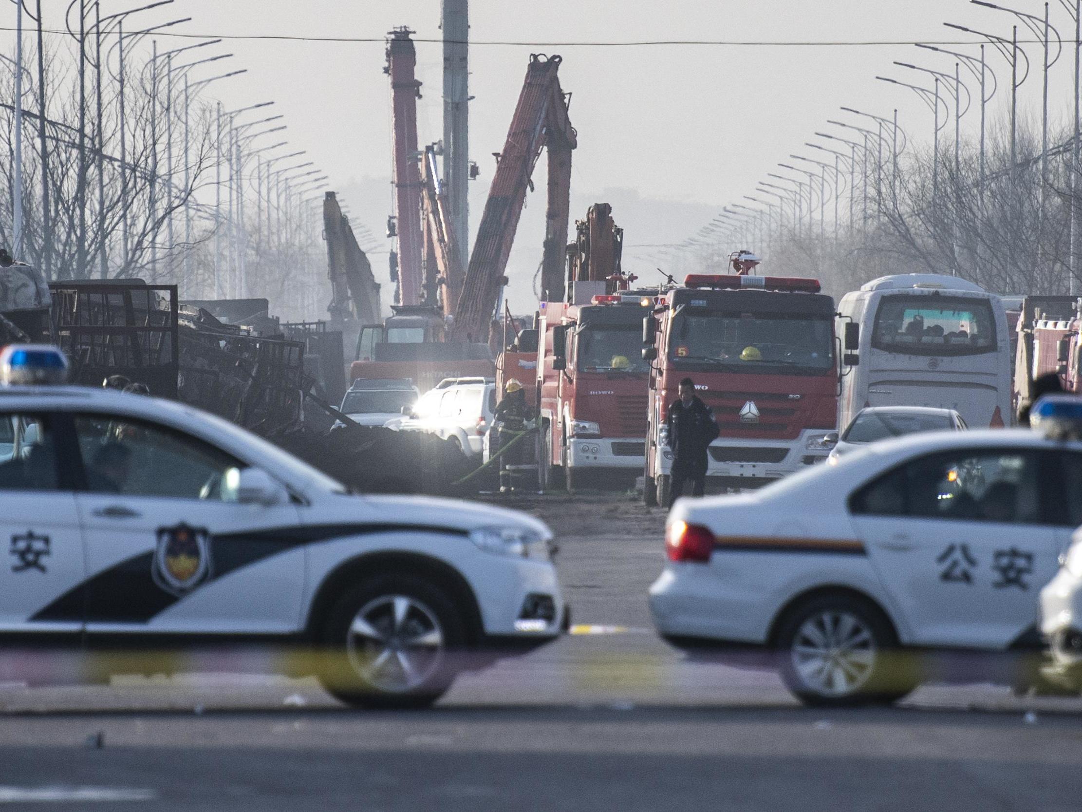 Chinese policemen and firemen work on the area after an explosion near a chemical factory in Zhangjiakou, some 200km northwest of Beijing, 28 November 2018 (Fred Dufour/