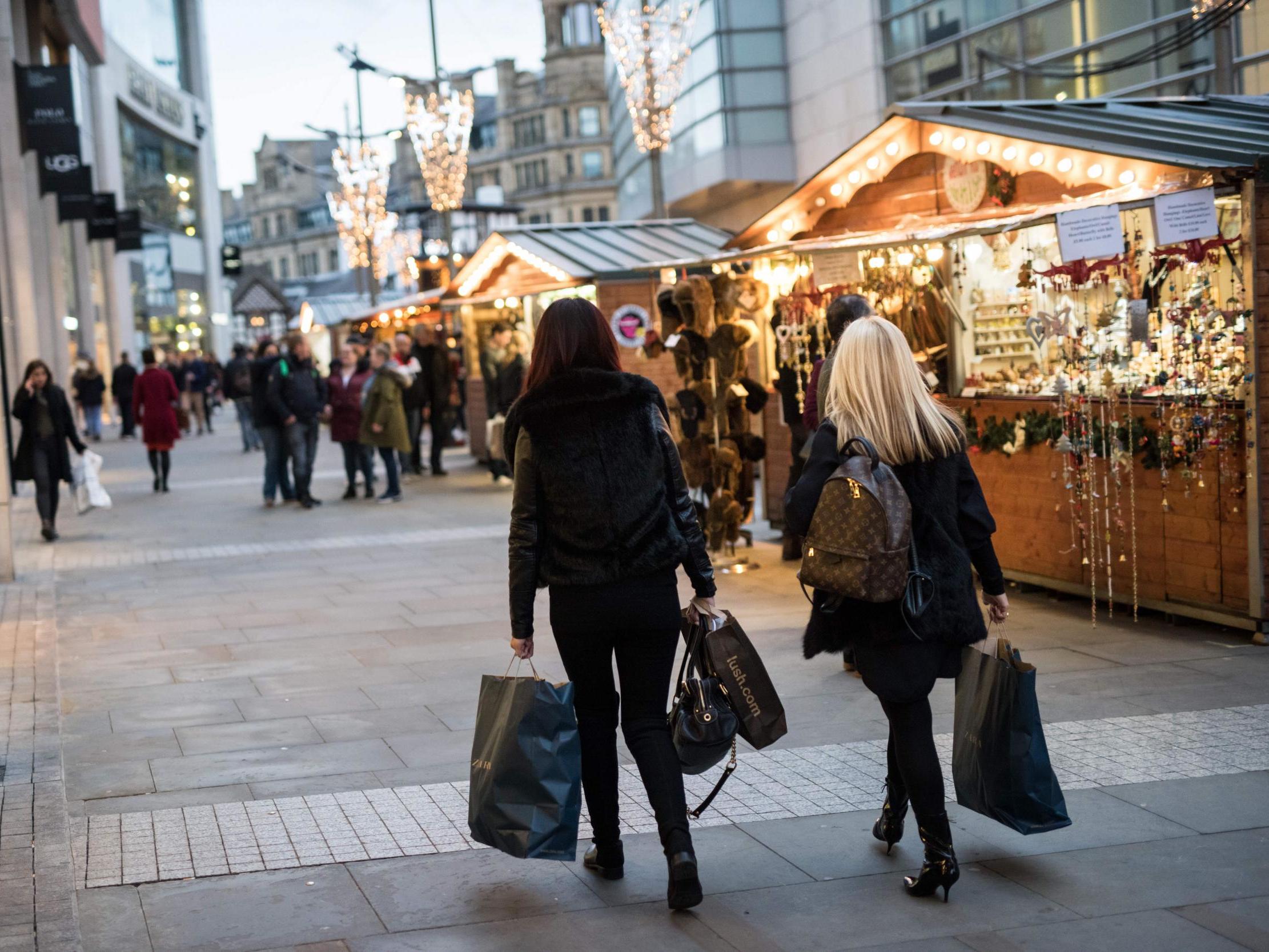 Members of the public carry their shopping by the stalls of the Manchester Christmas Market which is spread across the city centre in Manchester, UK, 9 November 2018 (Oli Scarff /