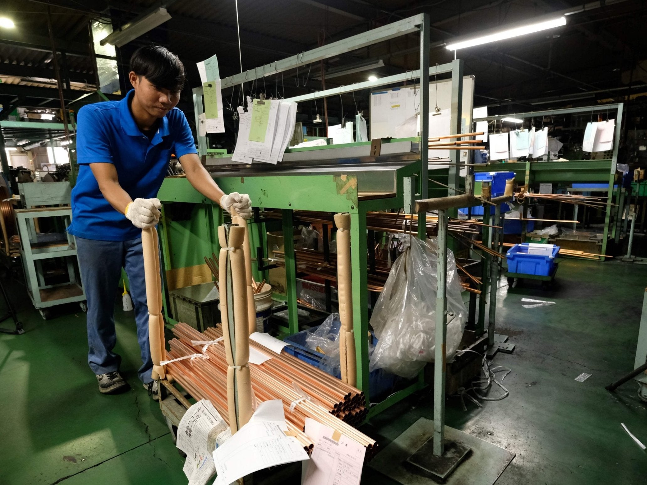 Jaman, an Indonesian worker, moving copper tubes at a Nakamoto Mfg factory in Oizumi, Gunma prefecture