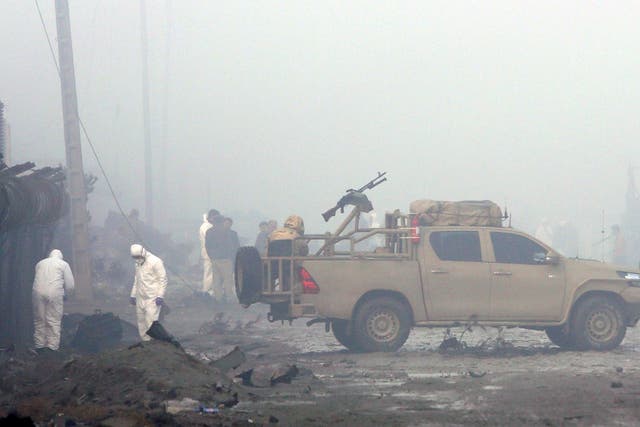 Afghan security forces inspect the site of a suicide bomb attack at a G4S compound in Kabul