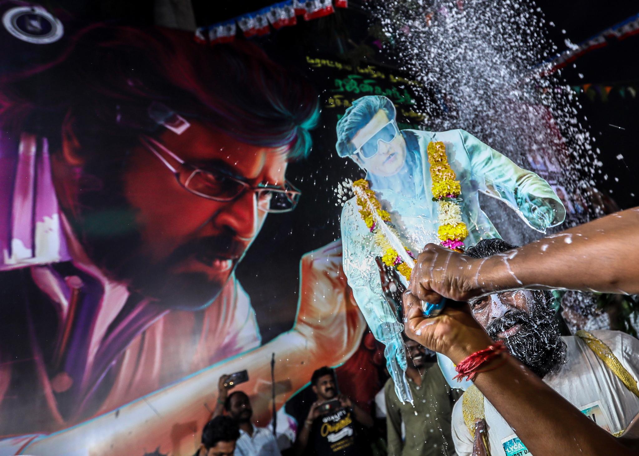A person sprays milk as they celebrate the release Indian director and actor Rajinikanth's long awaited film '2.0' in Mumbai, India