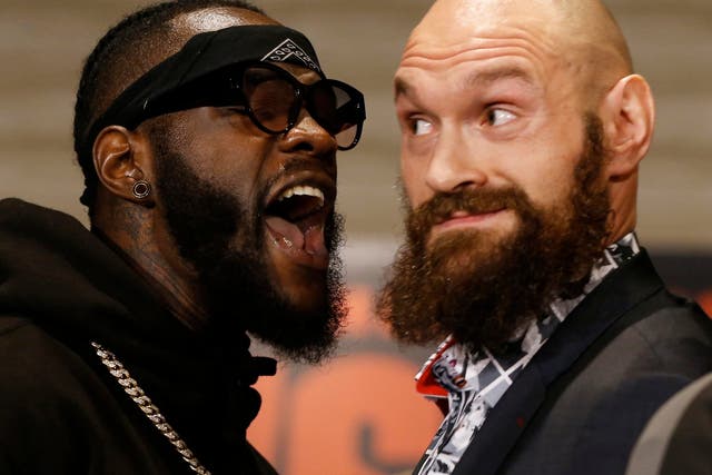 Deontay Wilder and Tyson Fury exchange words as they face each other at a news conference