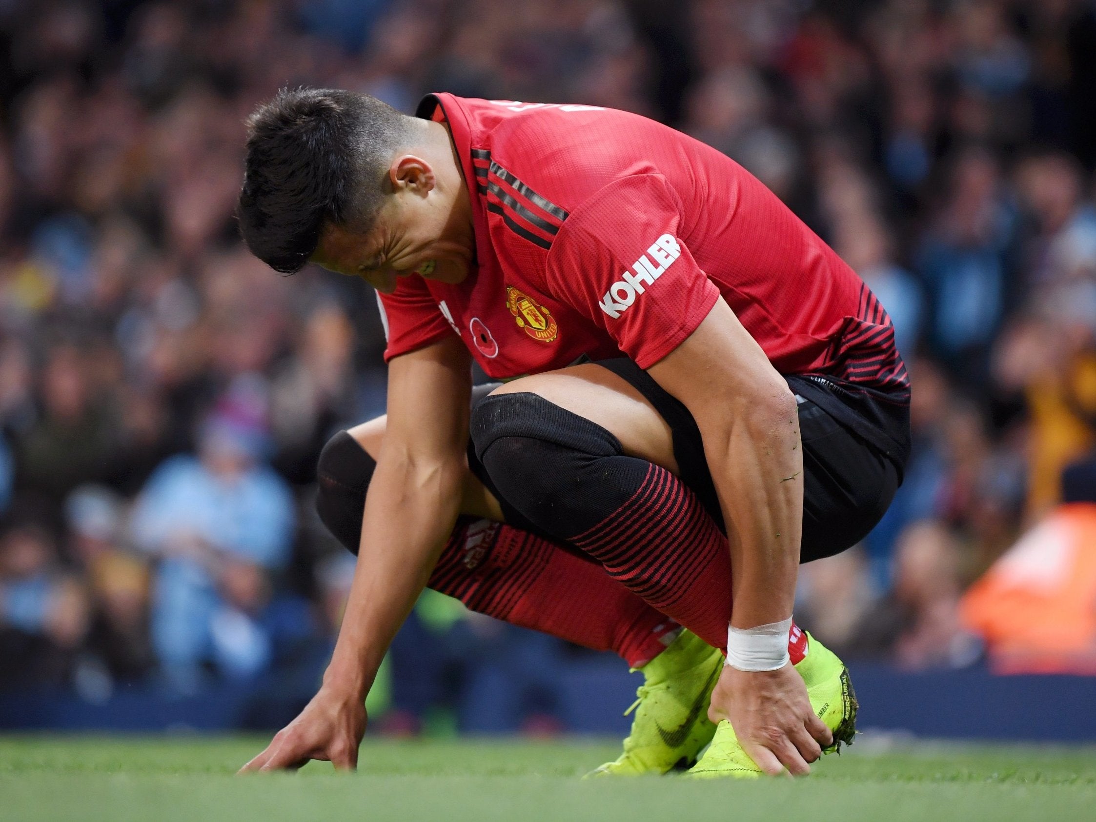 Alexis Sanchez of Manchester United holds his foot in pain