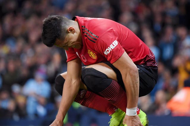 Alexis Sanchez of Manchester United holds his foot in pain