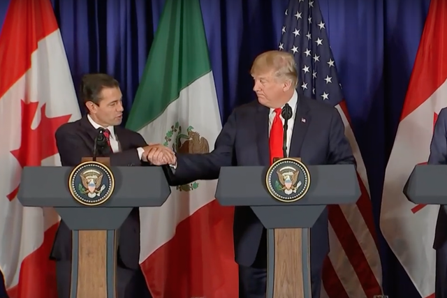 Donald Trump shakes hands with Mexican President Enrique Peña Nieto as the two sign the revised North American trade pact alongside Canadian Prime Minister Justin Trudeau 30 November 2018
