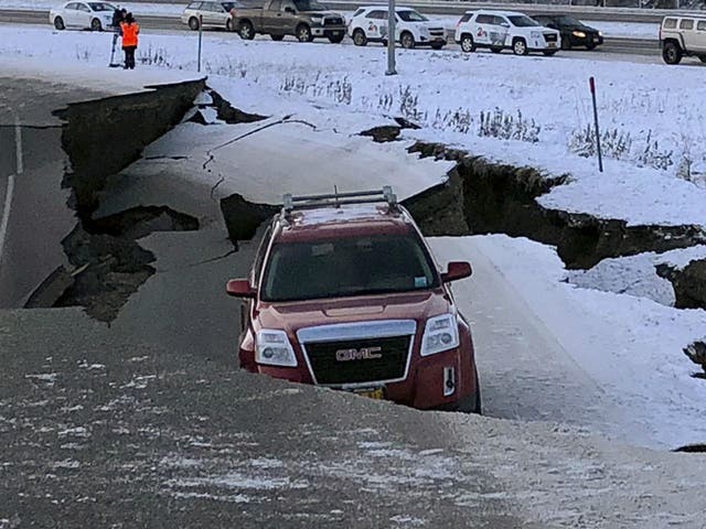 A car trapped on a collapsed section of the offramp of Minnesota Drive in Anchorage