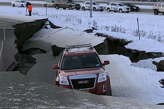 A car trapped on a collapsed section of the offramp of Minnesota Drive in Anchorage