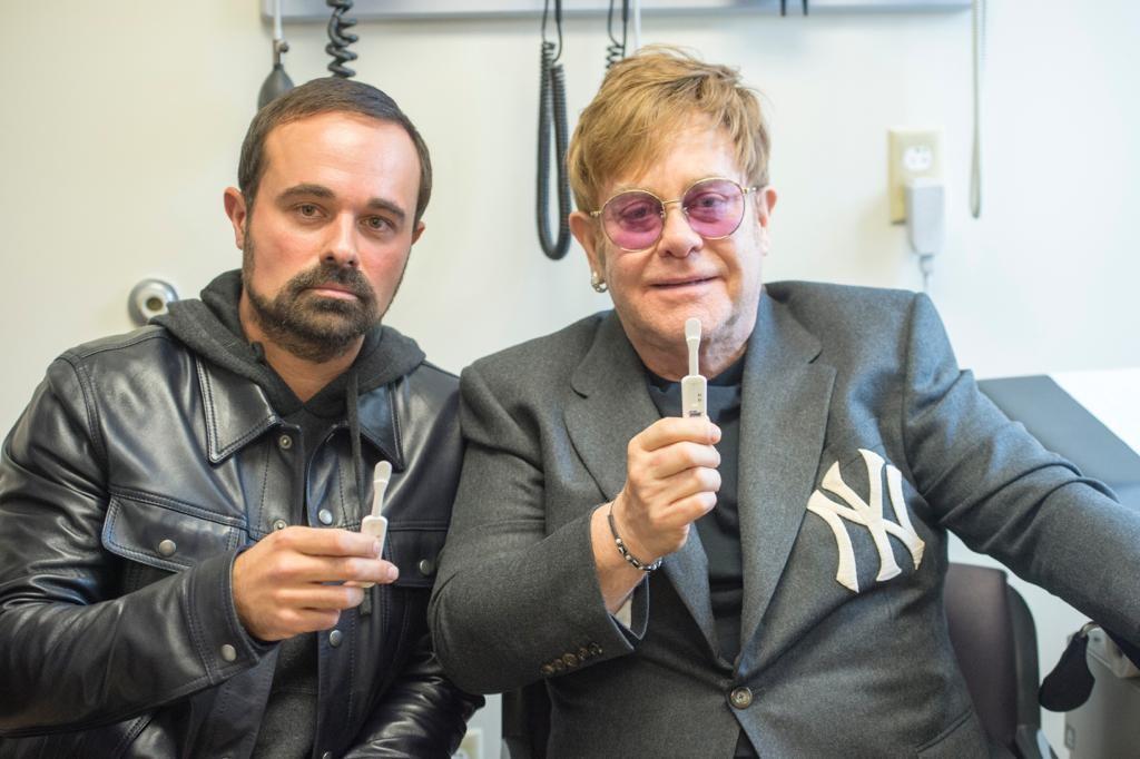 Sir Elton John and Evgeny Lebedev try out one of the most recent developments in testing, a simple mouth swab