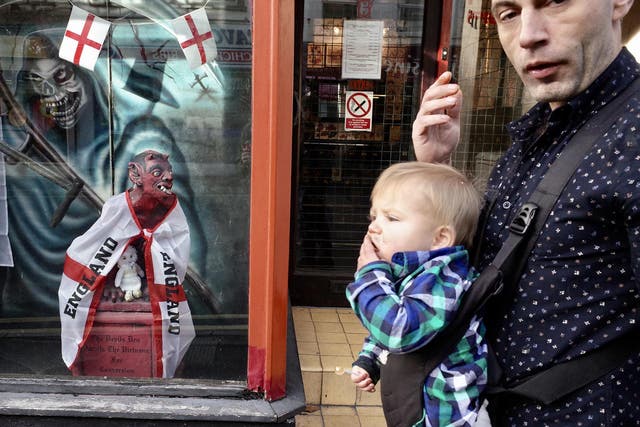 The devil draped in the St George’s cross barks from behind the window at a father and son on the street of Yeovil