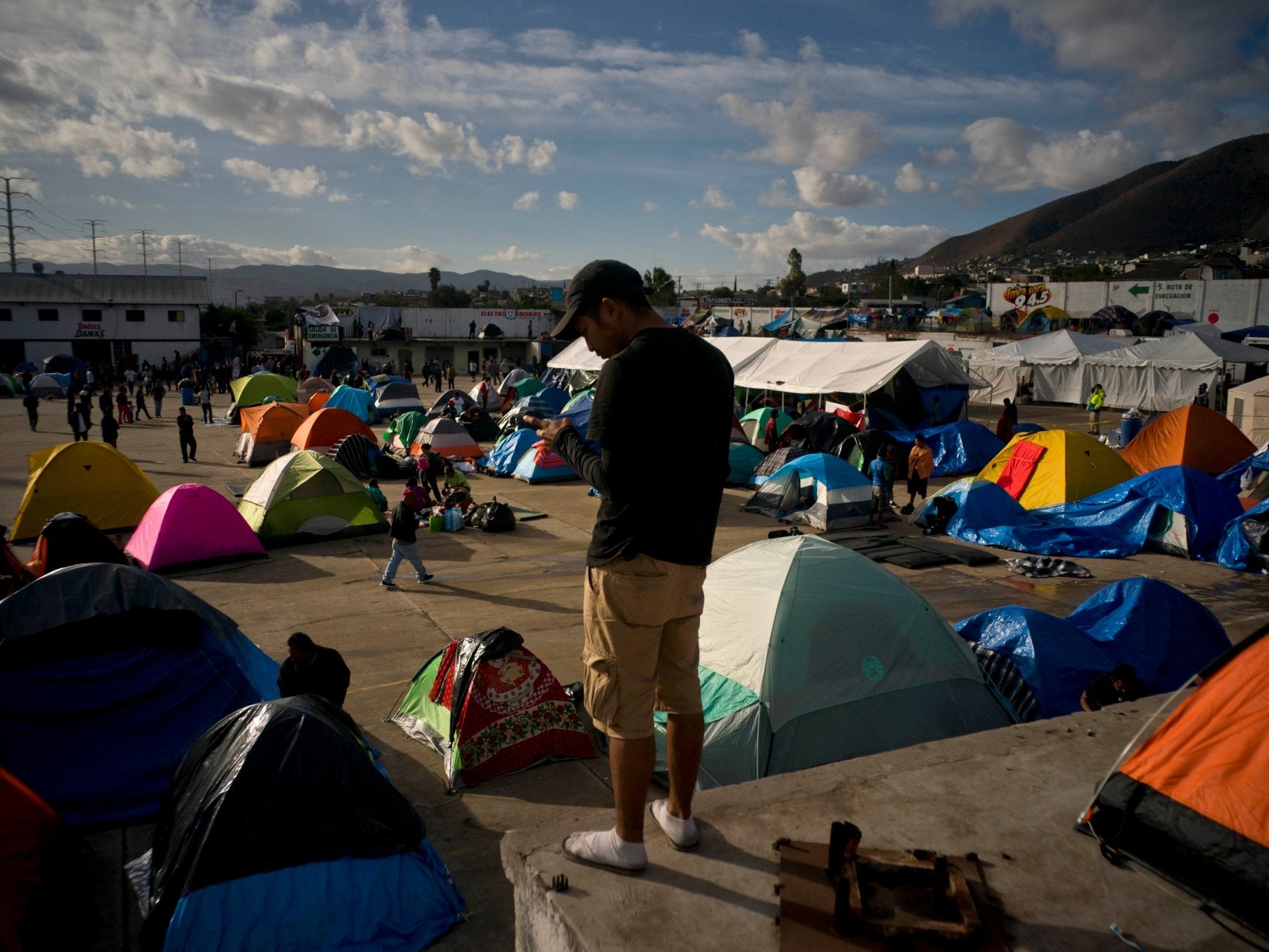 A migrant does a crossword puzzle at the new shelter where he and others were transferred after the sanitary conditions worsened at a previous shelter in Tijuana