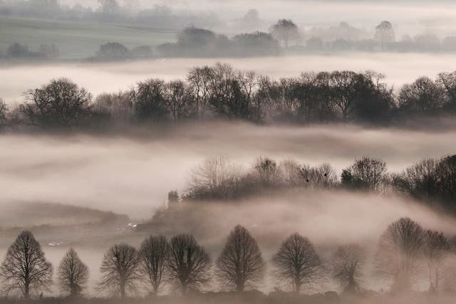 A low mist covers the fields as the sun rises over the Vale of Pewsey near Marlborough in Wiltshire