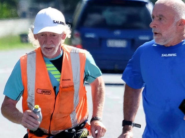 Perry Newburn, left, runs with support crew member Graeme Calder on State Highway 1 near Raumati, New Zealand