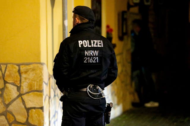 A police officer stands guard outside the Italian restaurant 'Osteria da Mario' as part of the mafia raids in Pulheim, Germany