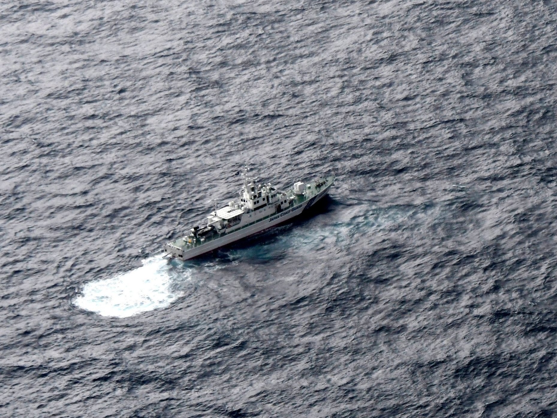 Japan's Coast Guard ship is seen at sea during a search operation for US Marine refueling plane and fighter jet