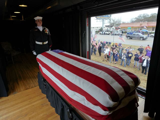 The flag-draped casket of former President George HW Bush passes through Magnolia, Texas as it makes its way via train