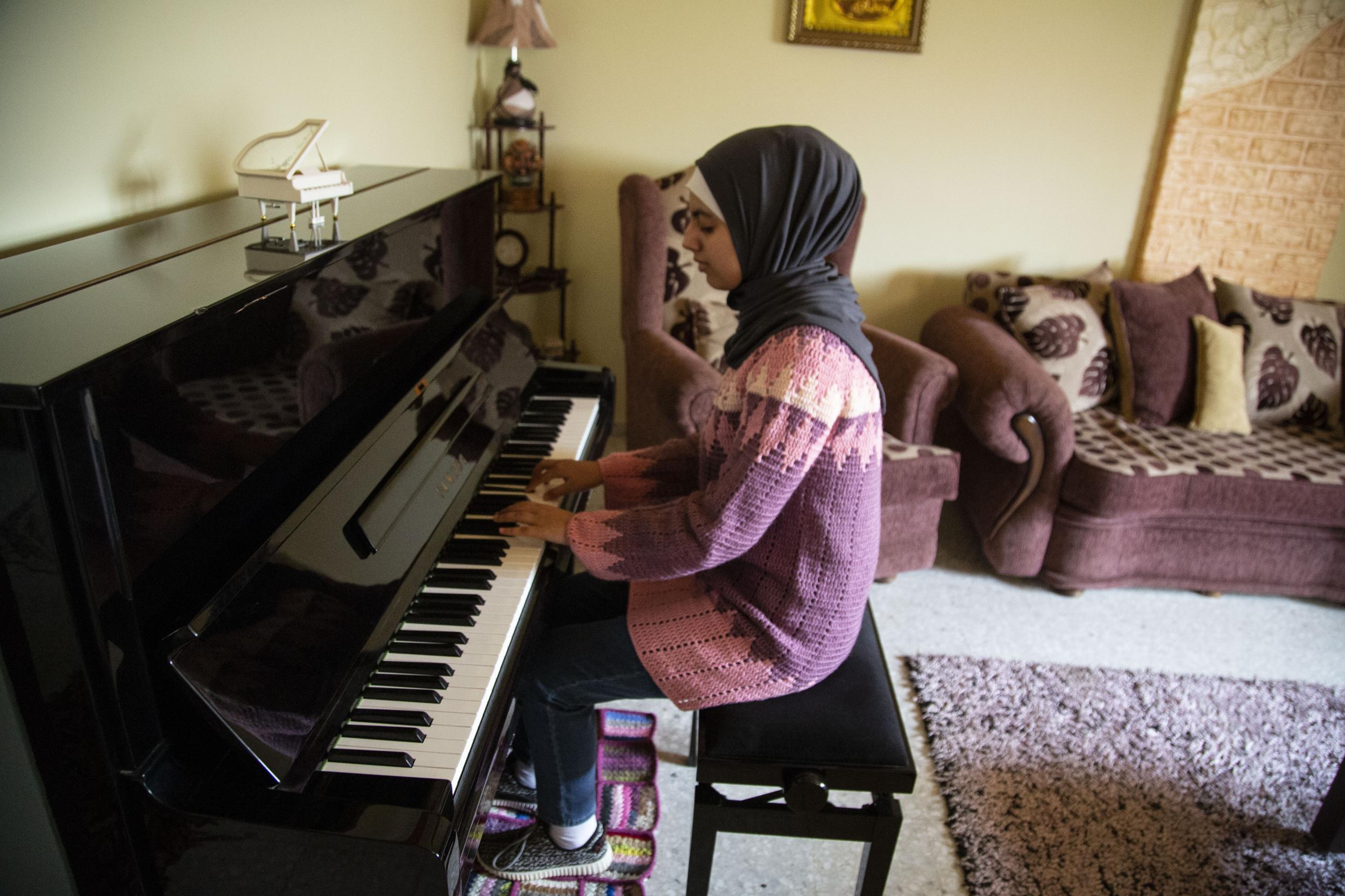 Yara plays her piano which took three years to get into Gaza and cost thousands of dollars