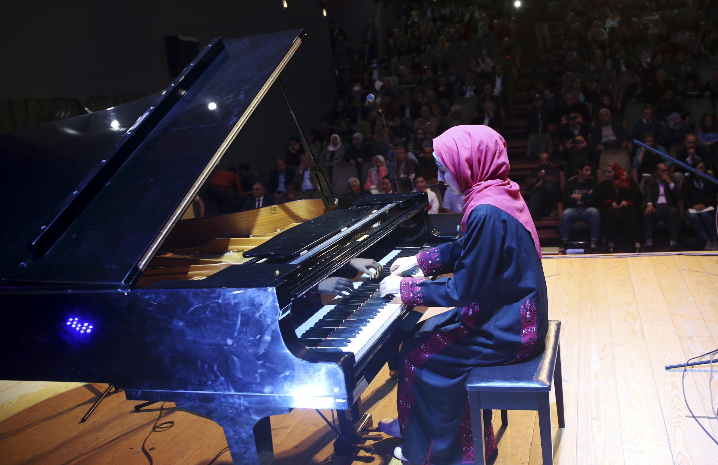 Thabit plays the piano during a concert to mark the debut of Gaza’s only grand piano after it was rescued from conflict
