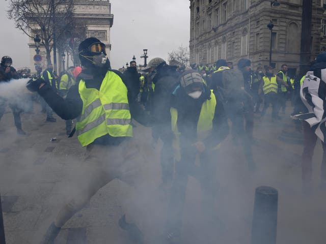 Police officers fire tear gas at protesters