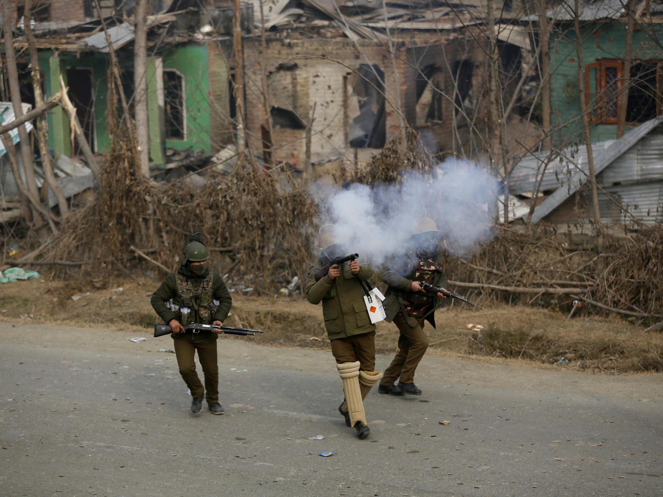 An Indian policeman fires a tear gas shell towards Kashmiri protesters