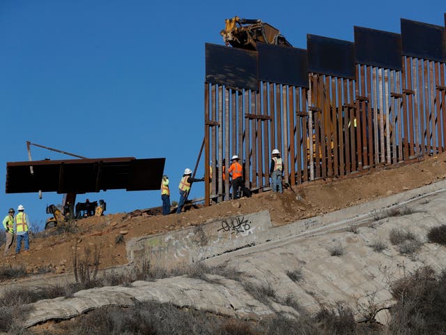 Workers add new sections to the US border wall near Tijuana, Mexico