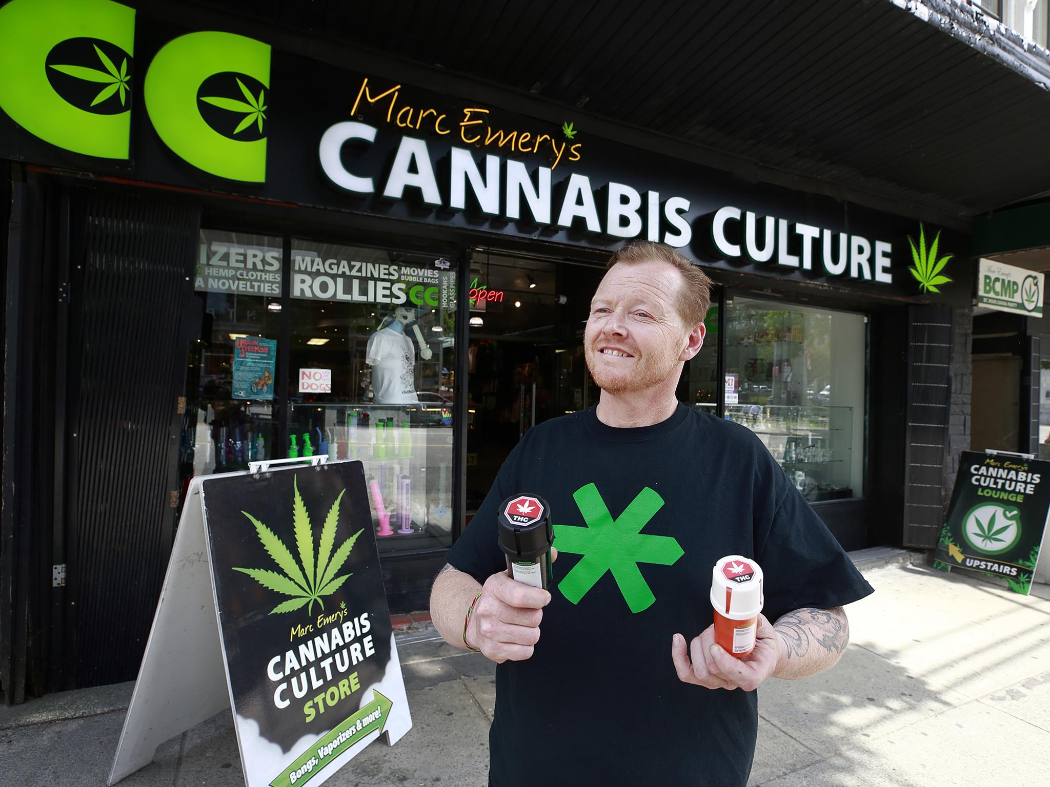 Authorised marijuana distributor John Berfelo stands outside Marc Emery’s Cannabis Cafe as he holds two accredited child resistant packaging containers for recreational cannabis for legalisation in Vancouver (Getty)