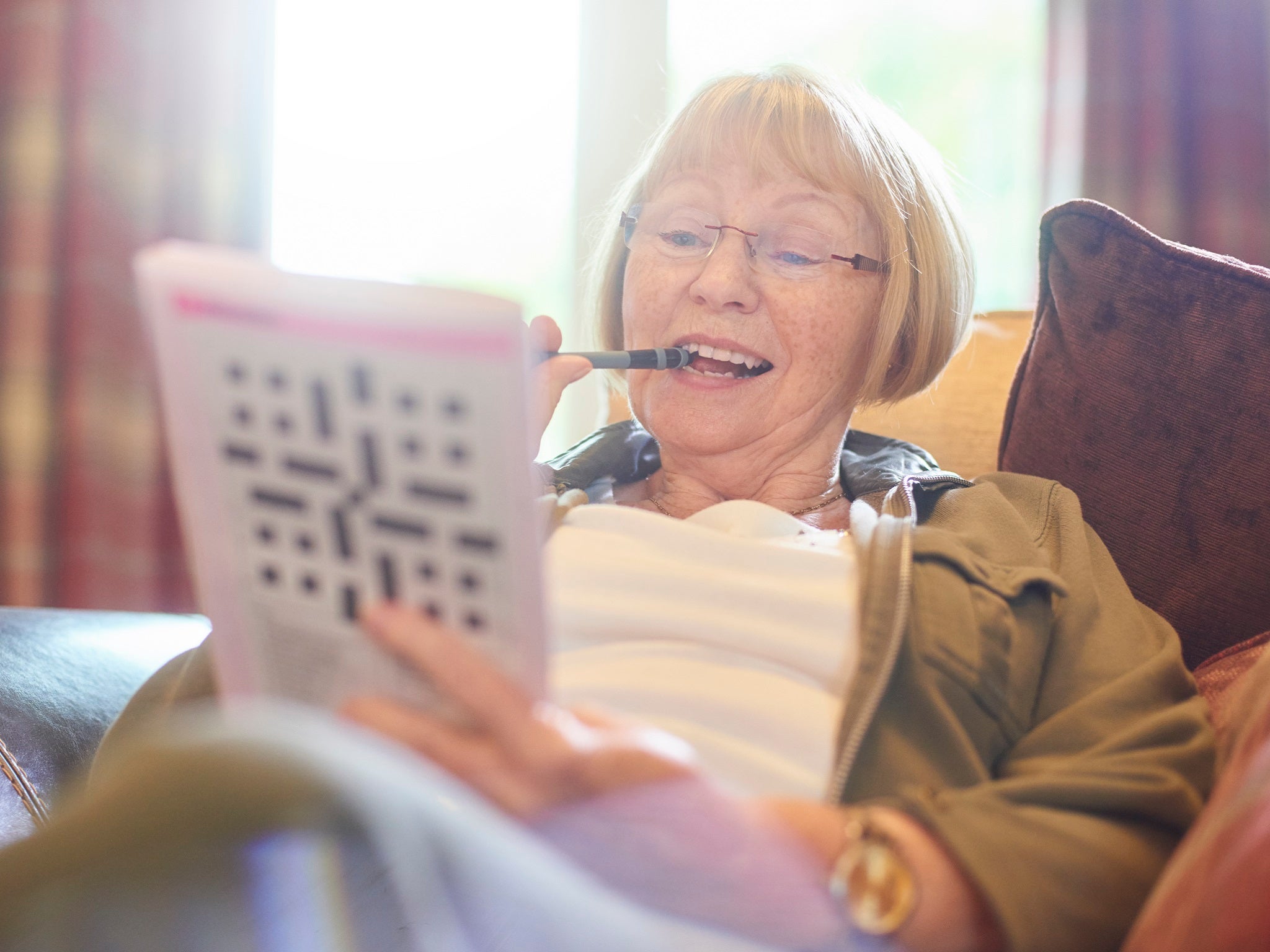 Woman doing crossword puzzle at home