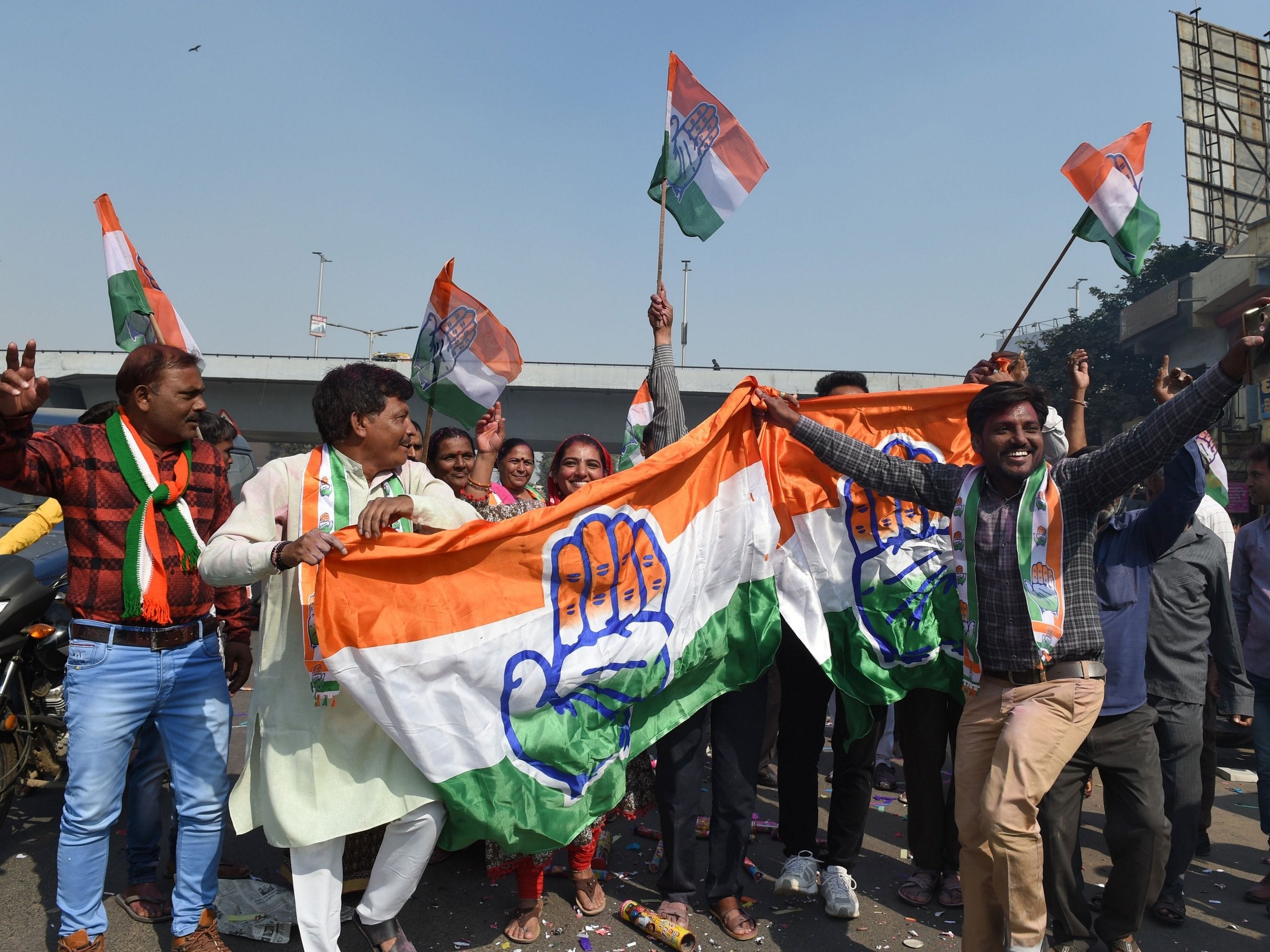 Indian Congress party supporters hold their party flag as they celebrate in Ahmedabad
