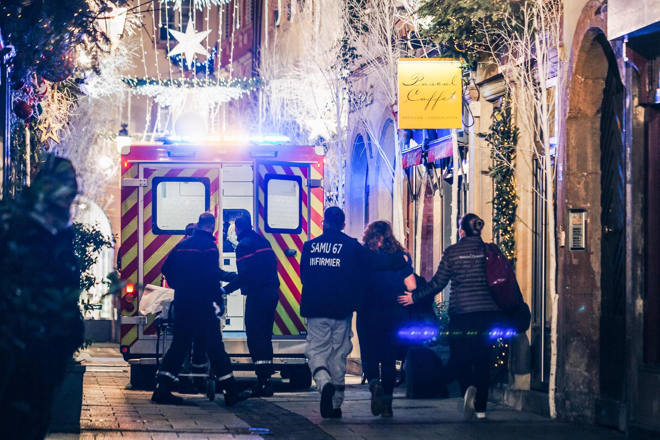 Emergency workers escort a woman from the scene