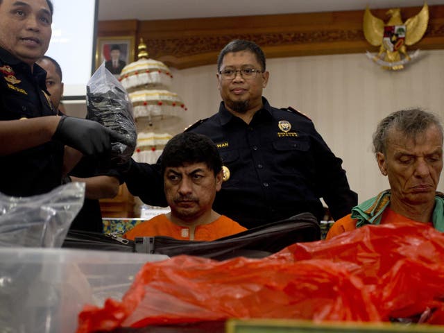 Indonesian customs officers display drug hauls in front of the Peruvian and the German suspects