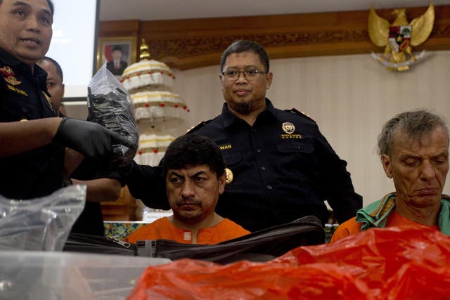 Indonesian customs officers display drug hauls in front of the Peruvian and the German suspects