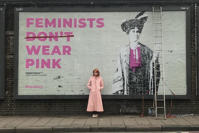 Scarlett Curtis stands in front of an artwork of suffragette leader Emmeline Pankhurst