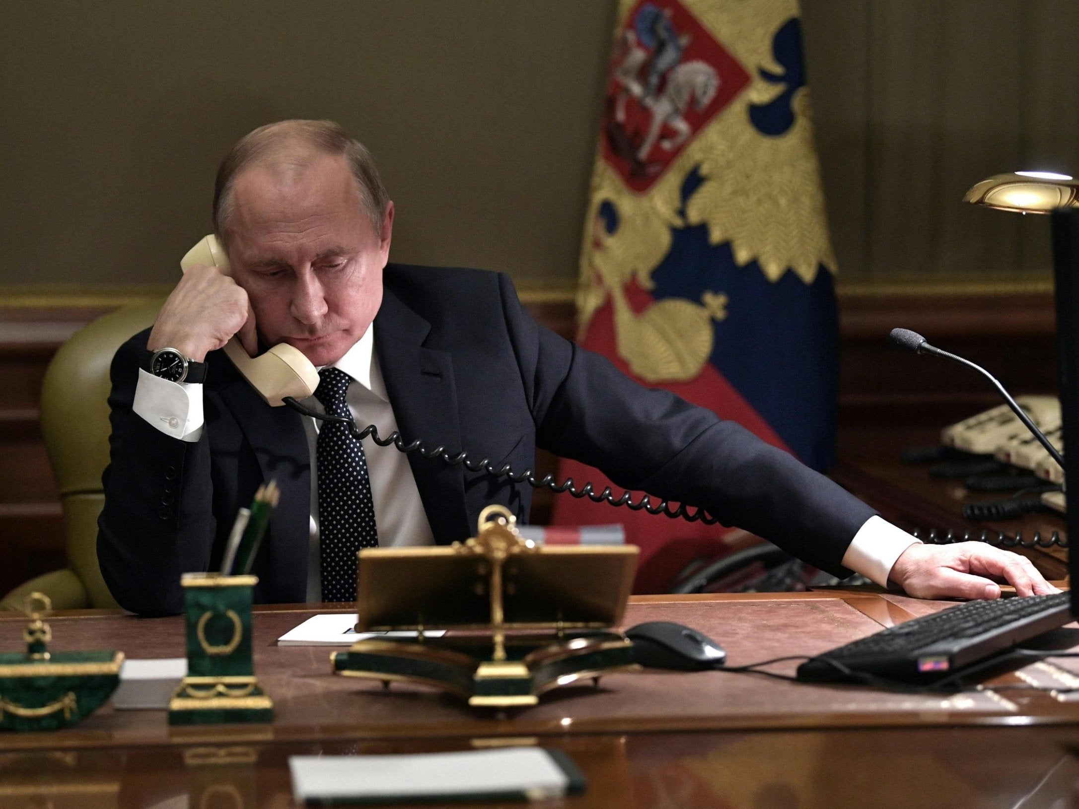 Vladimir Putin speaks on the phone in his office in Saint Petersburg