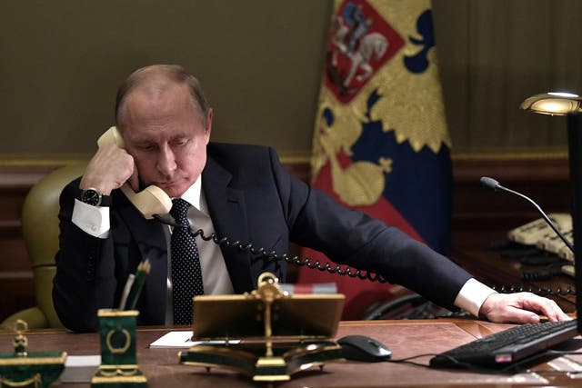 Vladimir Putin speaks on the phone in his office in Saint Petersburg