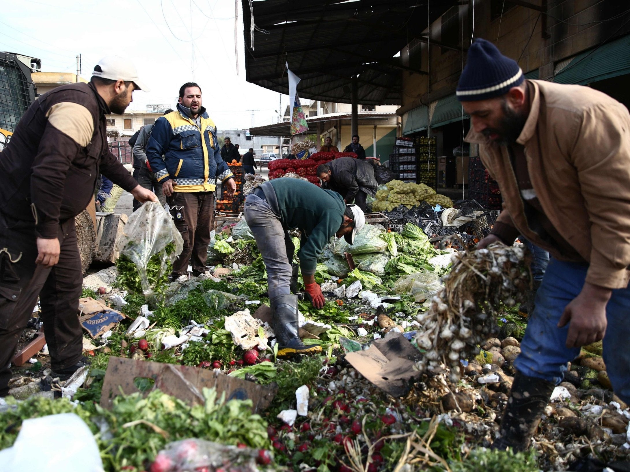 People try to salvage vegetables after a car bomb reportedly exploded near a position of pro-Turkey fighters in a market in the northern Syrian city of Afrin, on 16 December 2018 (Nazeer Al-Khatib /