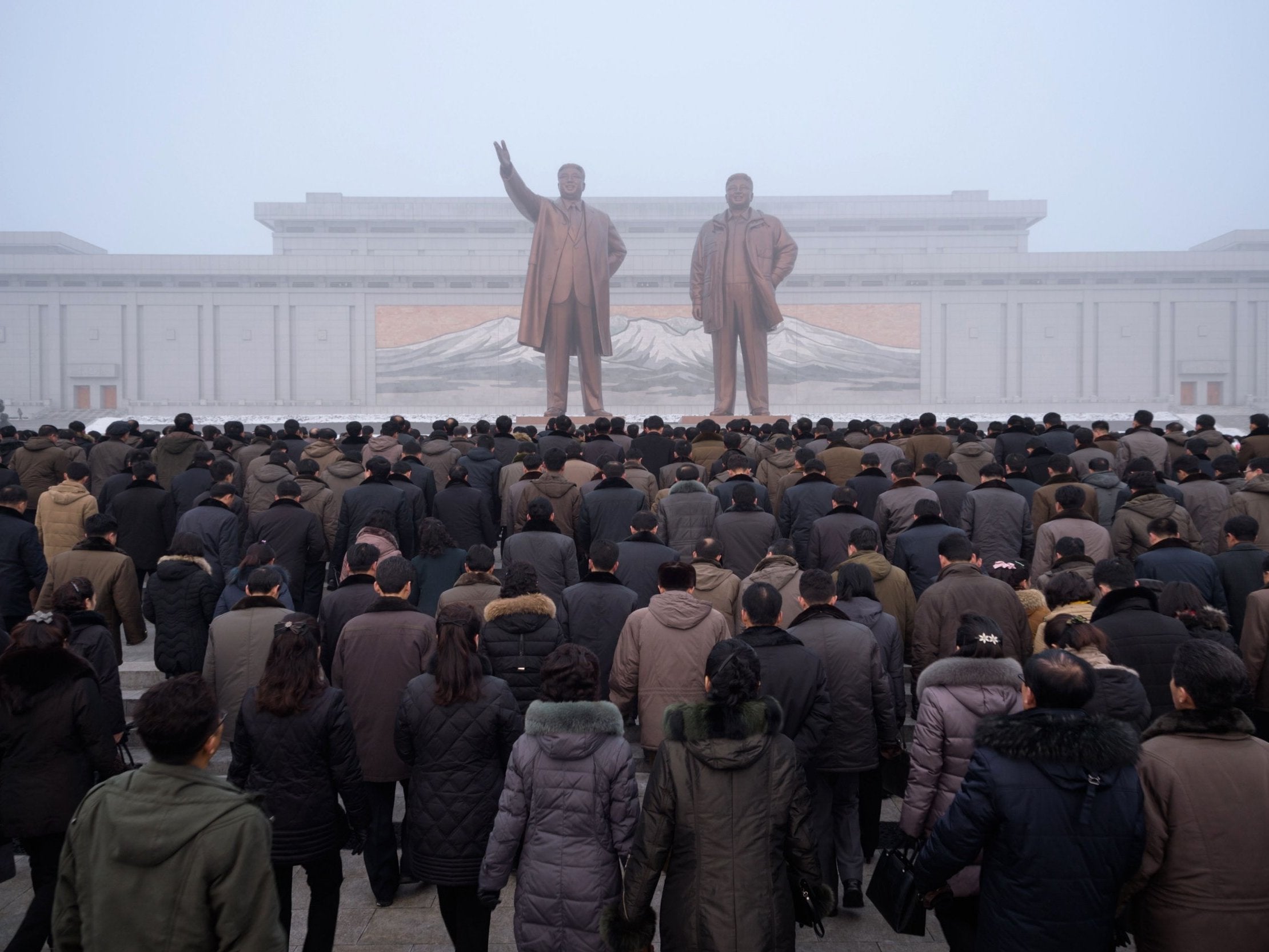 Pyongyang residents prepare to bow before statues of Kim Il Sung and Kim Jong Il during National Memorial Day on Sunday