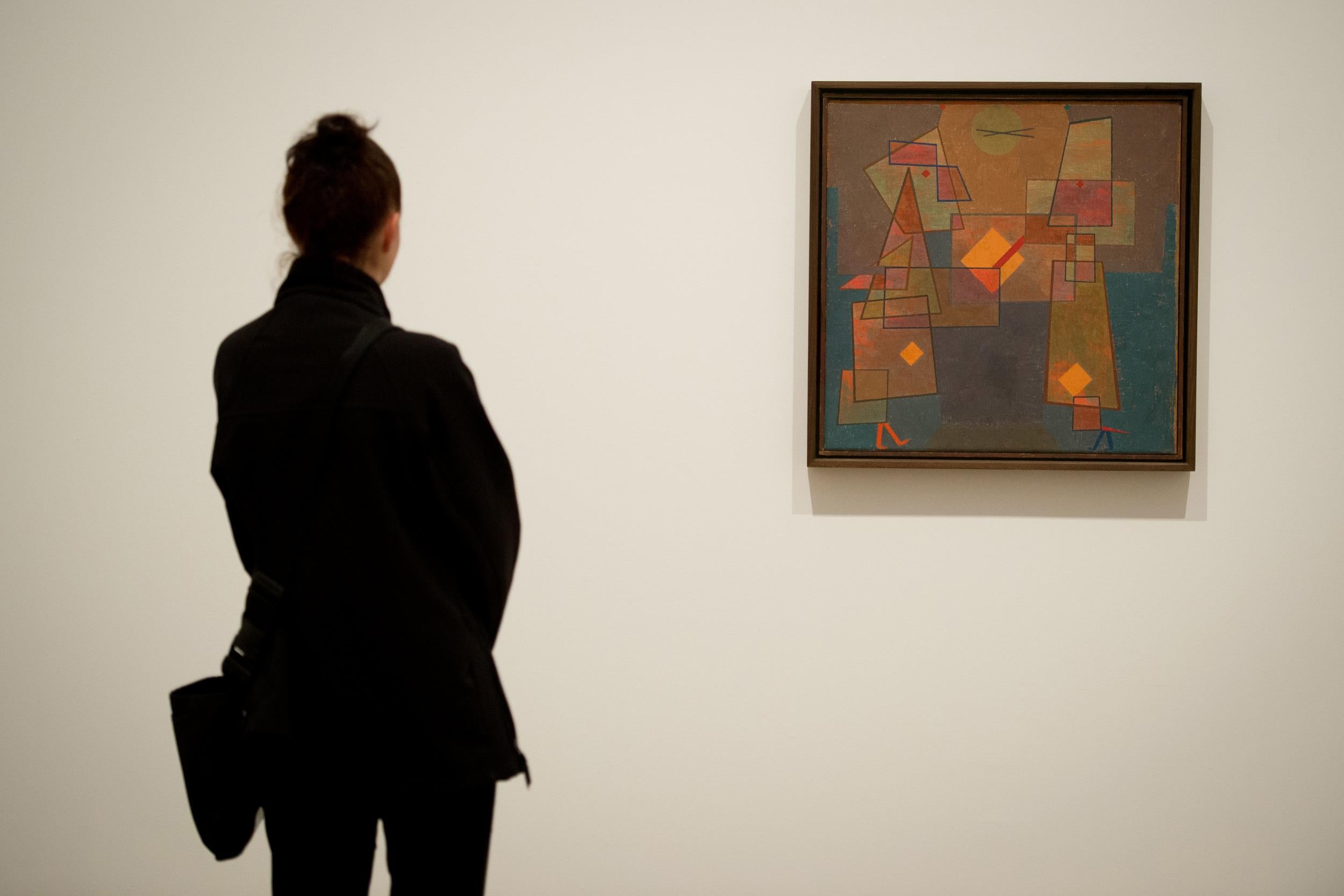 A woman stands beside a work entitled “Dispute” by Paul Klee at the press preview of an exhibition of his work, “Paul Klee: Making Visible” at the Tate Modern in London, England, on 14 October, 2013. (LEON NEAL/AFP/Getty Images)