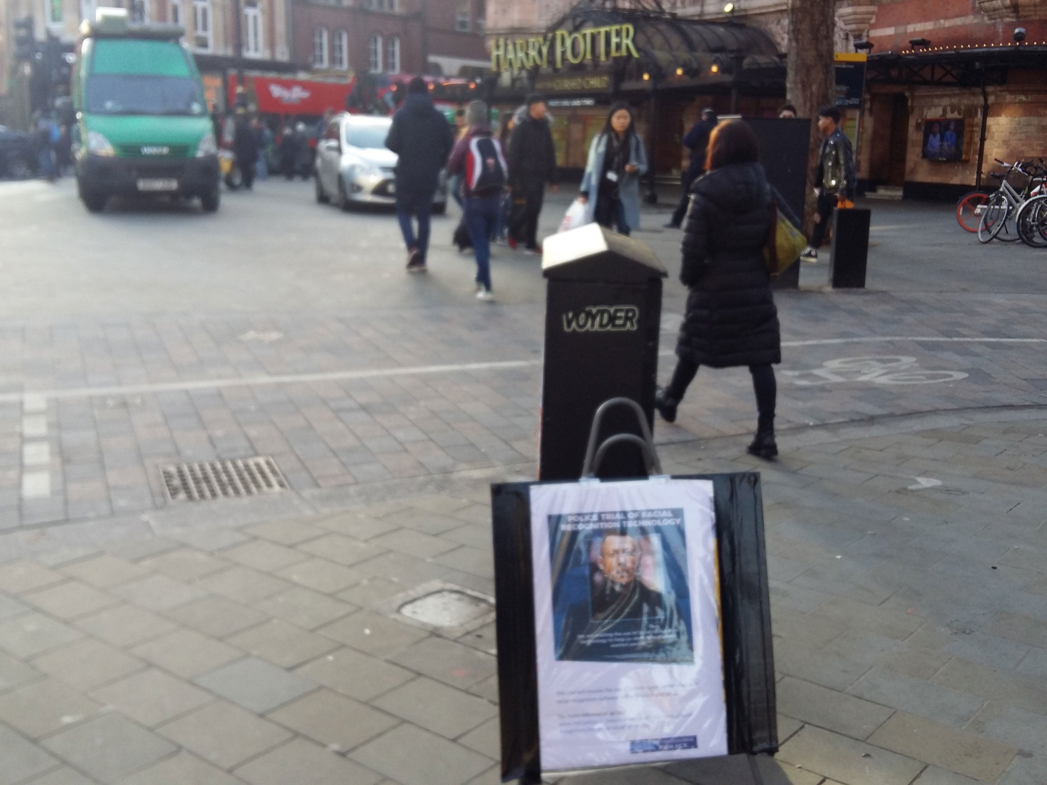 A sign saying facial recognition technology is in use ahead of an unmarked police van mounted with cameras in London’s West End in December 2018